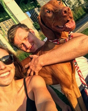 Golden-hour family selfie: Sara and her husband hugging a happy Tucker